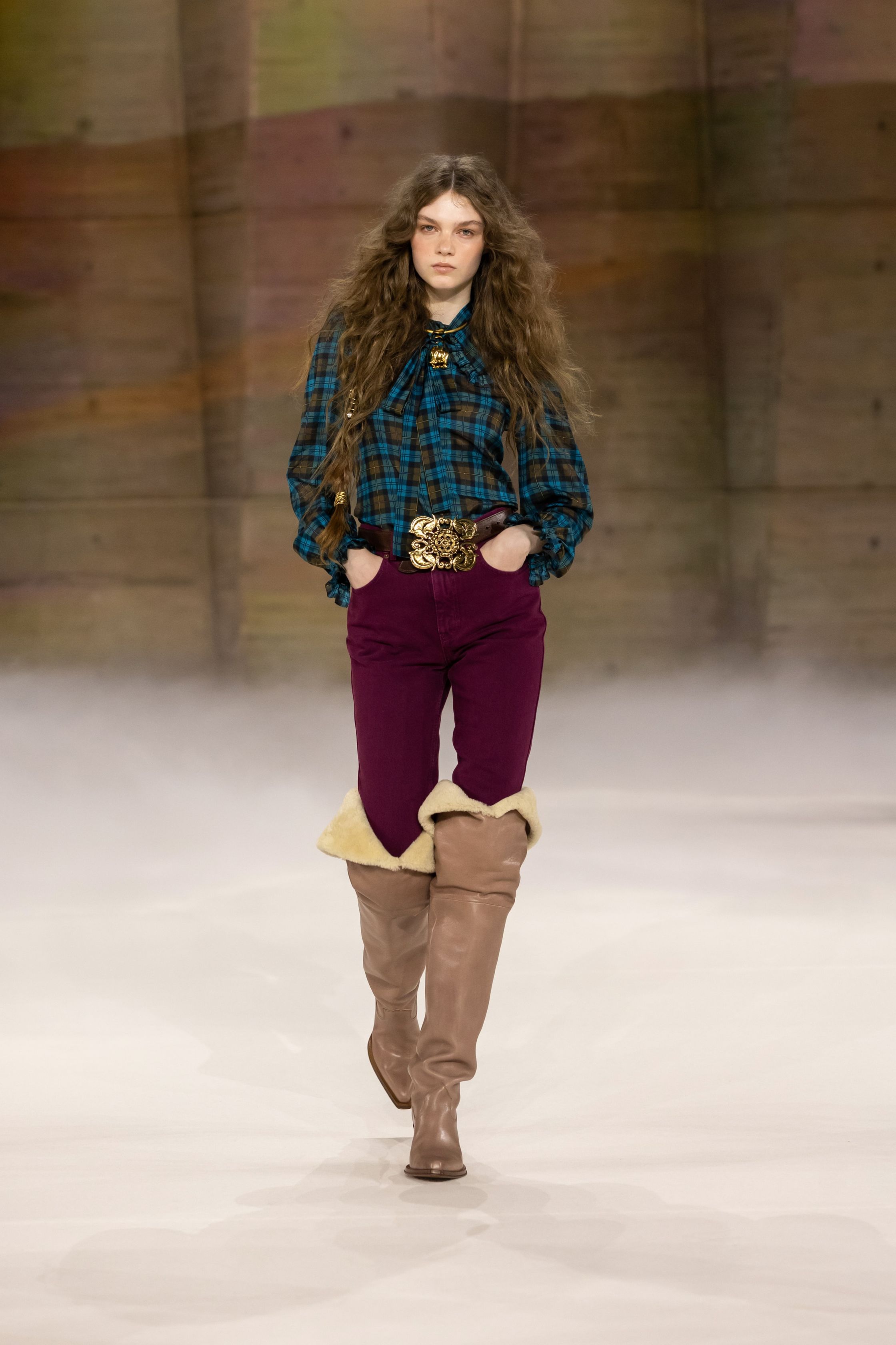 Chloé在2026秋冬继续书写品牌标志性的波西米亚浪漫，通过流动长裙、皮革长靴与柔软披风构建自由而诗意的女性形象。系列色调以大地色、酒红与米色为主，搭配轻盈薄纱与羊毛外套，使整体造型既温暖又富有层次。民族图案、长流苏与复古轮廓让整个系列充满旅行与冒险气息，呈现出典型的Chloé式自由精神-顽石频道趋势研究